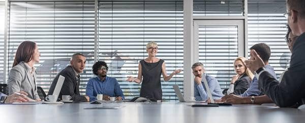Female CEO talking to her colleagues during a business meeting at conference table.